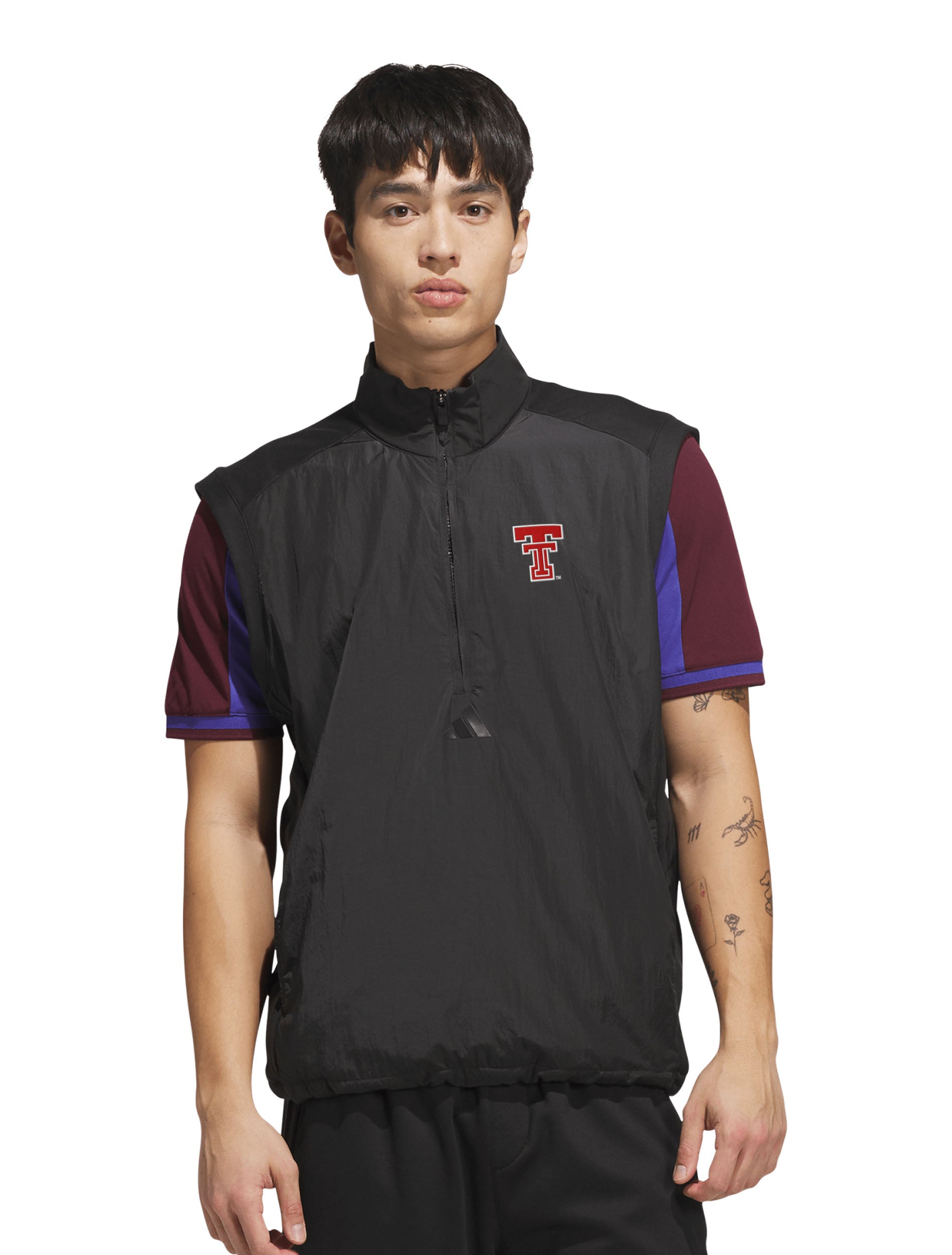 Model wearing the black half-zip golf vest over a short sleeve polo