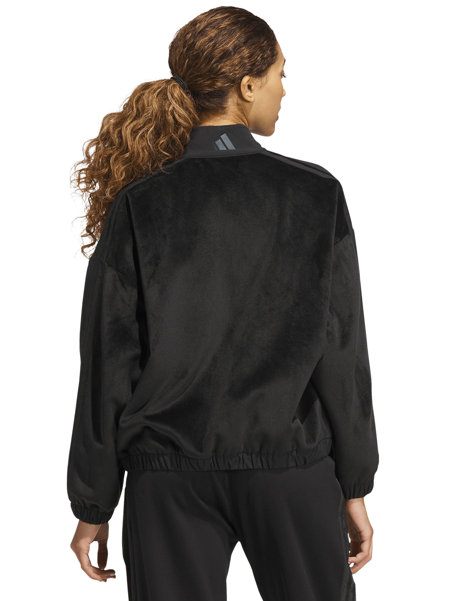 Model wearing the black Adidas women's velvet bomber jacket, back view with a grey Adidas logo at the back neck