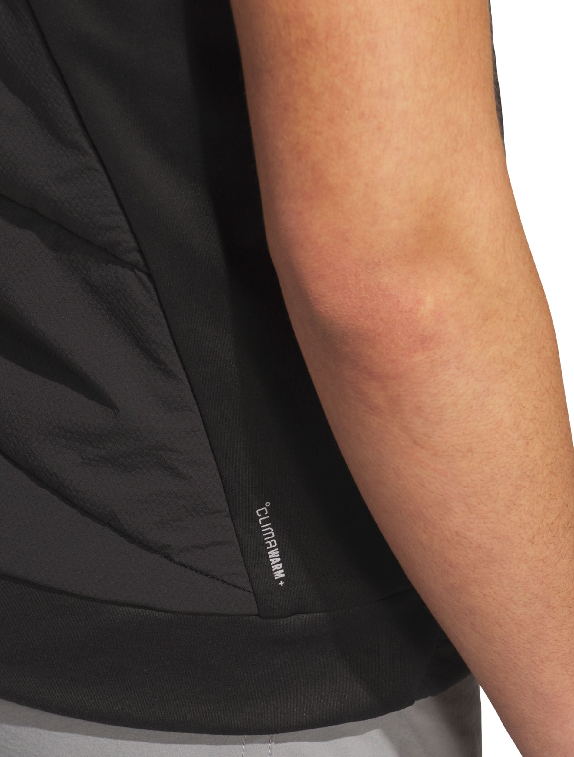 Close-up of the ripstop shell, stretch knit side panel and ClimaWarm+ logo at the hem