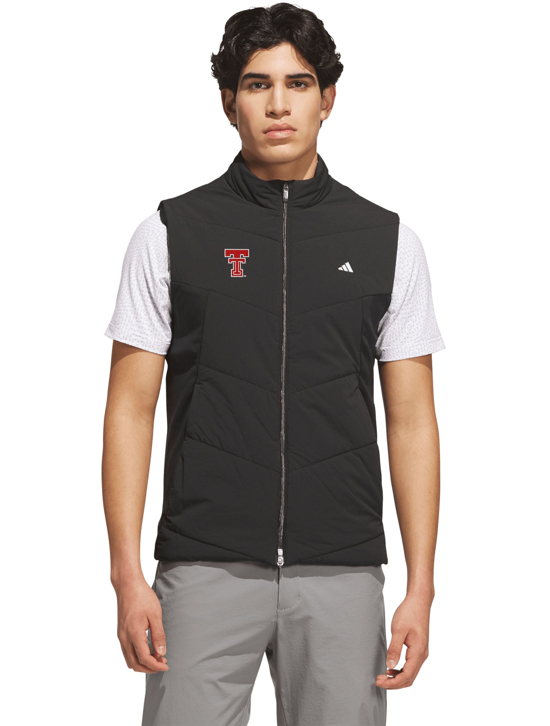 Model wearing the black quilted golf vest zipped over a white polo