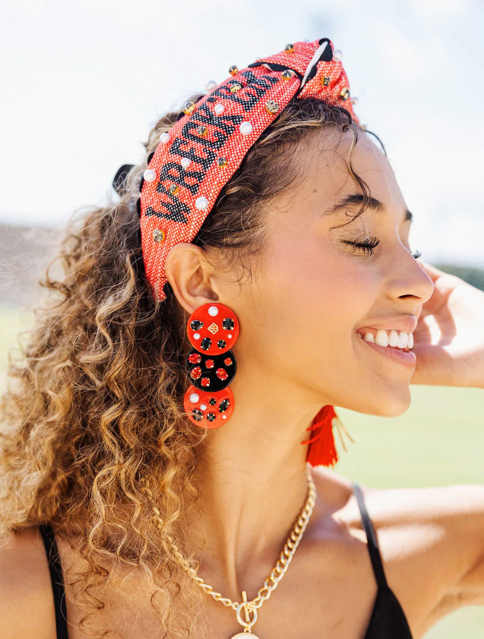 Model wearing the red Texas Tech “Wreck ’Em Tech” cross stitch headband with red beaded earrings