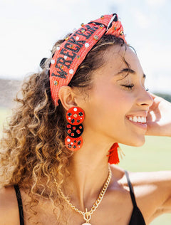 Model wearing the red Texas Tech “Wreck ’Em Tech” cross stitch headband with red beaded earrings