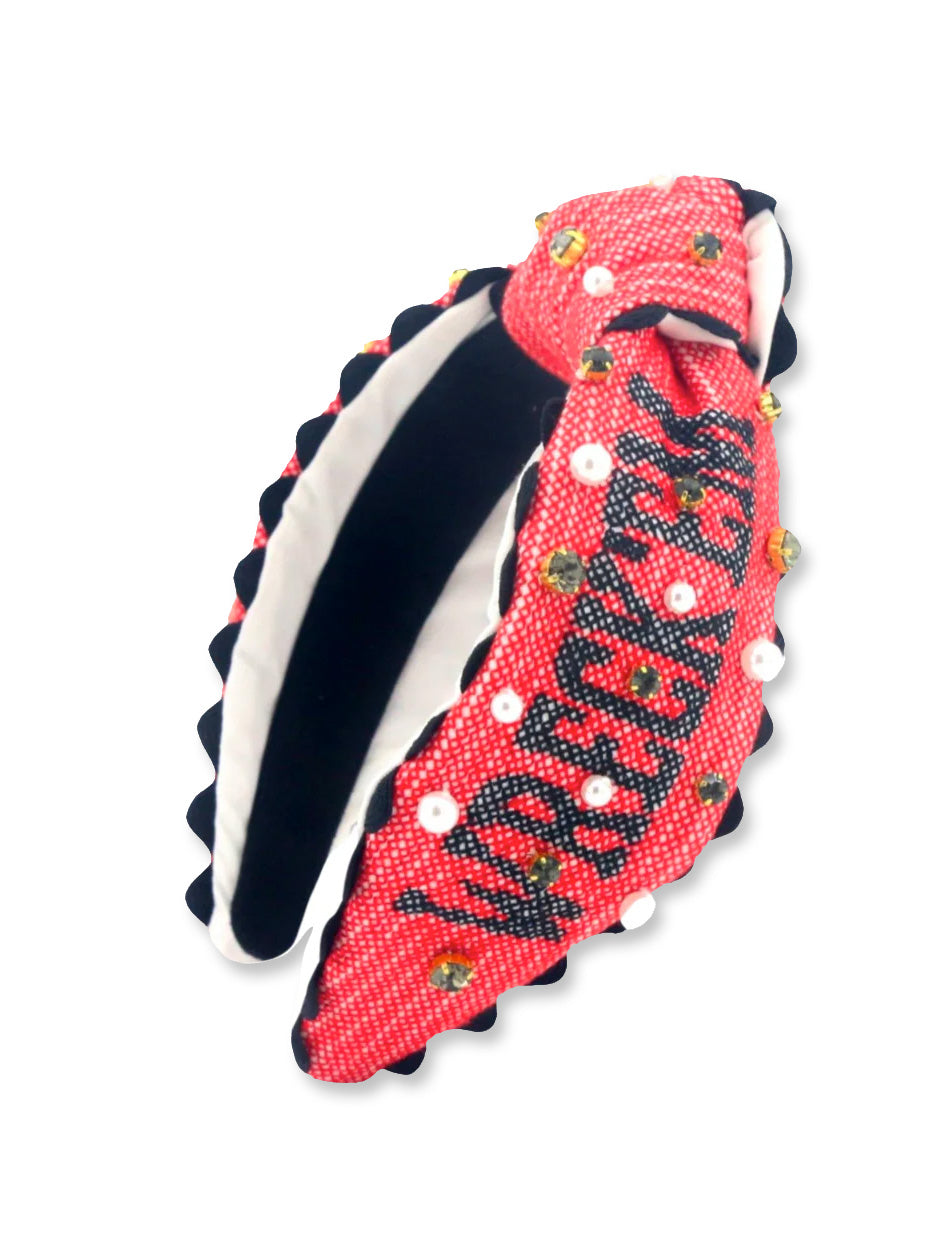 Red knotted headband with “Wreck ’Em” cross-stitched in black, scattered with pearls and small gold Double T charms