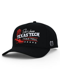 Black Texas Tech snapback cap at an angle, with a red cowboy boot and She's from Texas Tech across the front