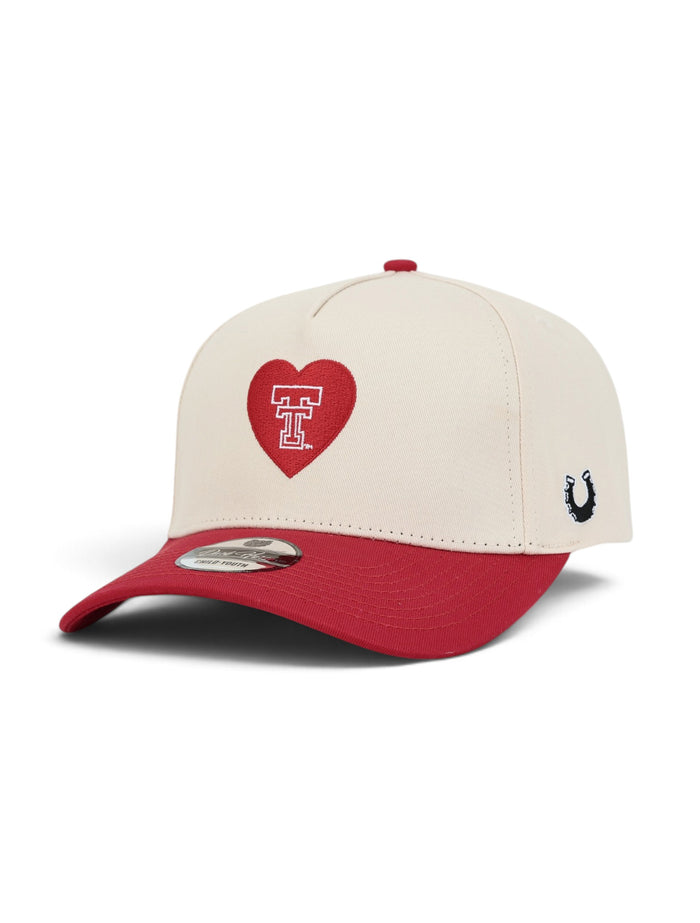 Cream youth Texas Tech cap with a red brim, at an angle, showing the Double T outlined in white inside a red heart