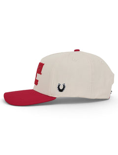 Side of the tan Texas Tech cap showing the Dark Horse horseshoe on the panel