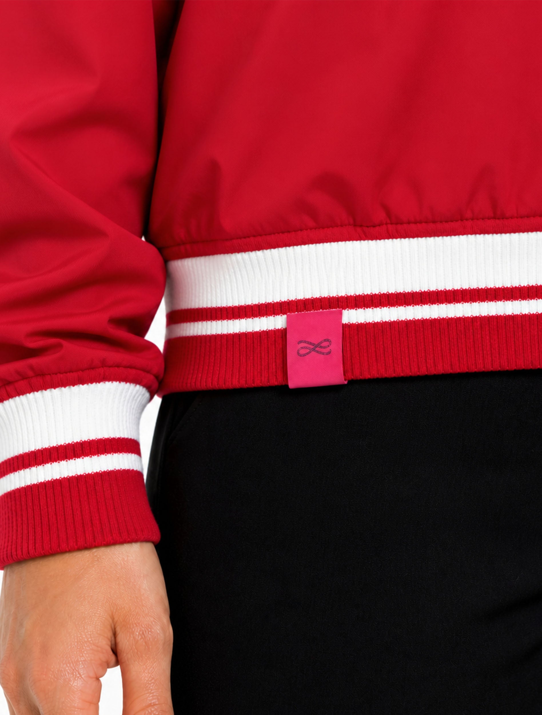 Close-up of the striped ribbed hem and cuff with the pink Lusso tab