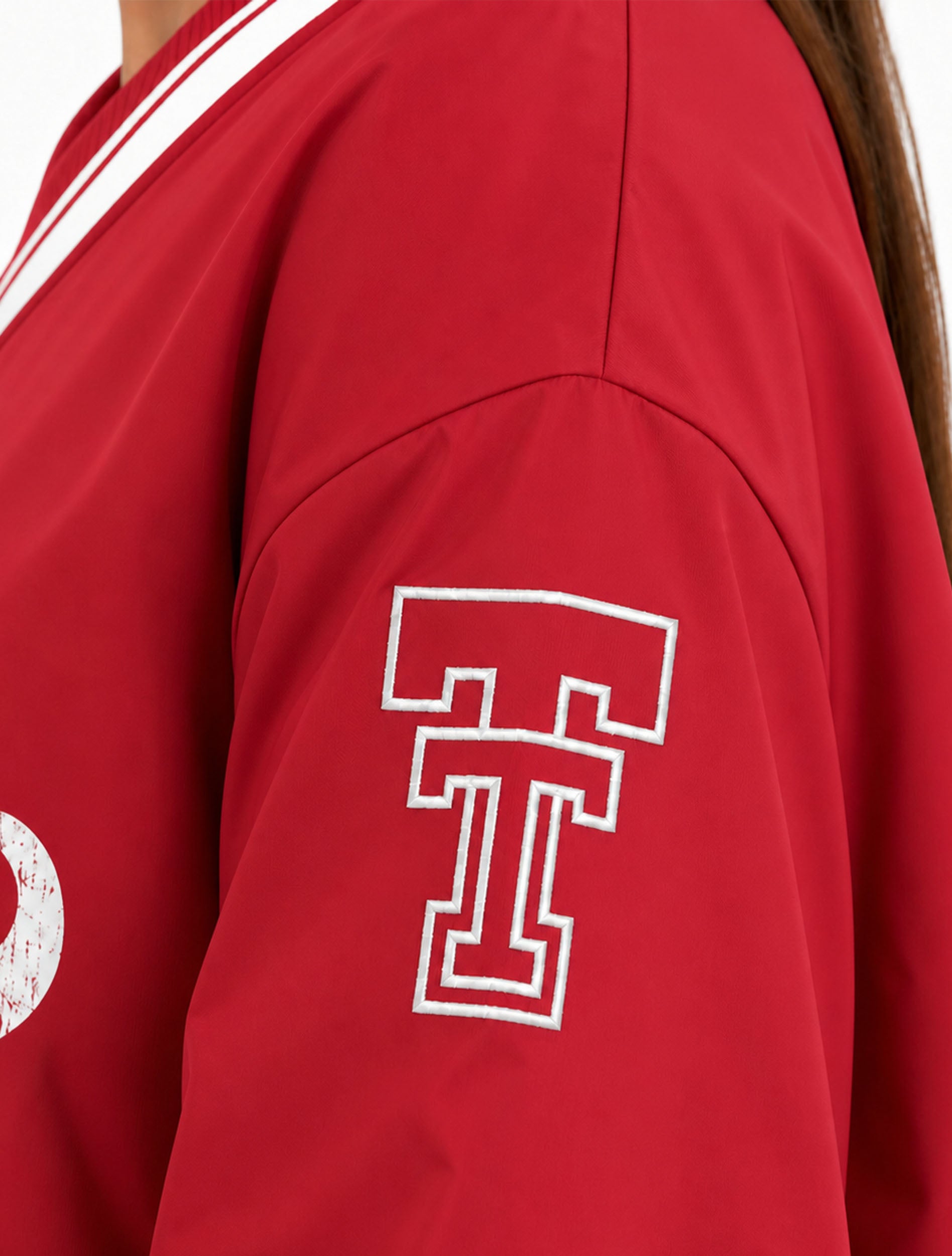 Three-quarter view of the red V-neck pullover showing the embroidered throwback Double T on the left sleeve