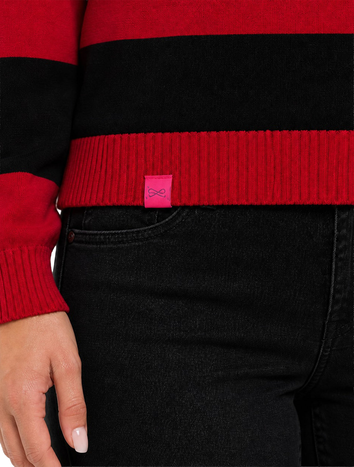 Close up of the red ribbed hem on the Lusso Texas Tech Silvia striped polo with the pink Lusso tag