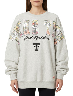 Model wearing the grey Pressbox Texas Tech Hilda BMOC oversized crew fleece with floral patchwork TEXAS TECH lettering, Red Raiders script and a black Double T