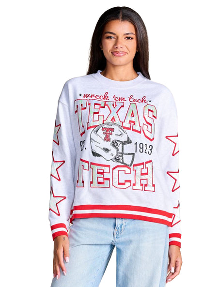 Model wearing a heather grey crewneck sweatshirt with iridescent TEXAS TECH letters, a sequin Double T helmet and red and white striped cuffs and hem