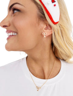 Model wearing the gold Texas Tech vault Double T stud earrings and matching Double T necklace over a white tee
