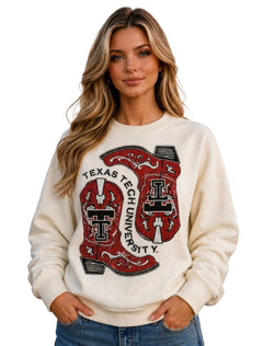 Model wearing the Texas Tech crewneck sweatshirt with two rhinestone cowboy boots on the front and TEXAS TECH UNIVERSITY arched between them