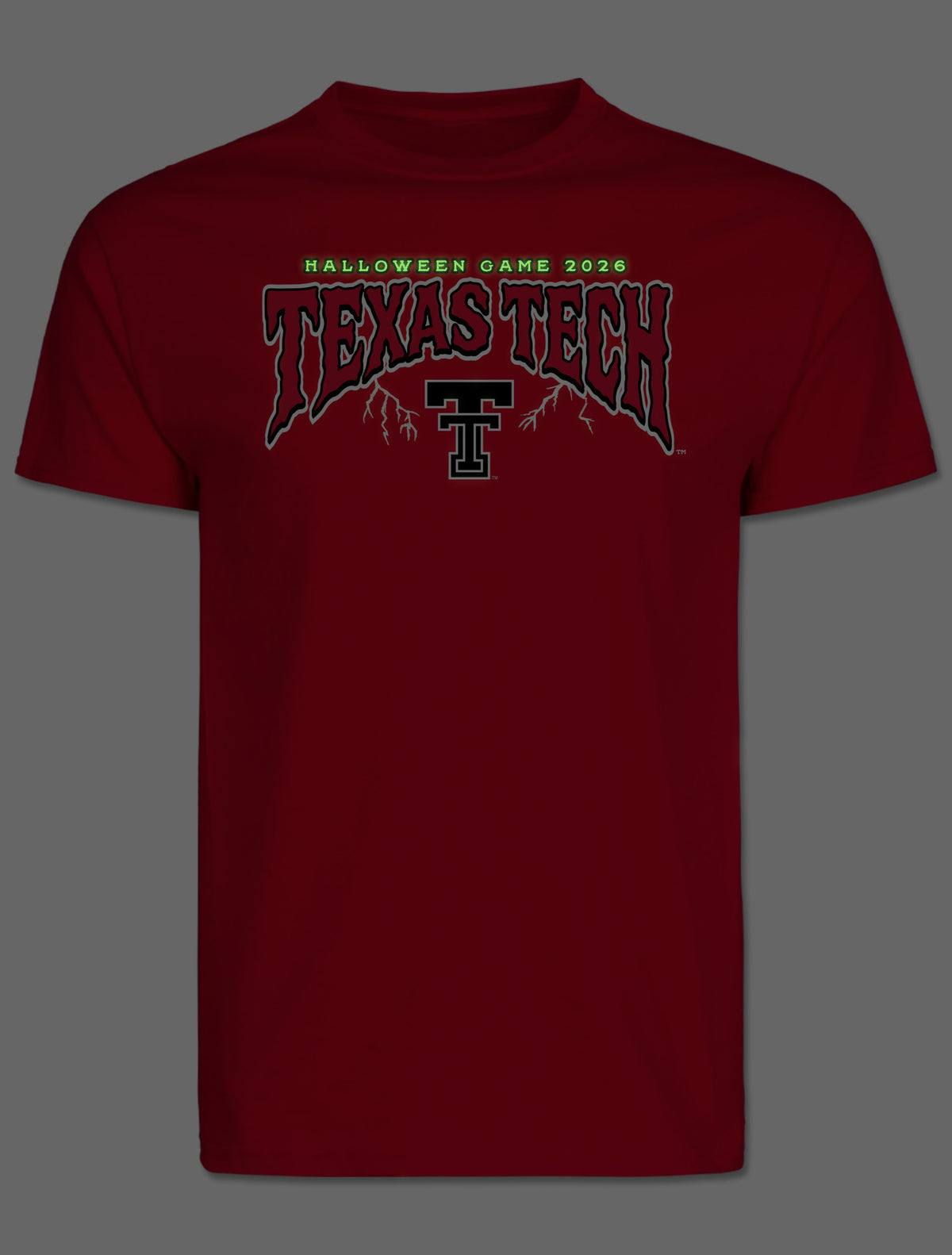 Front of the tee photographed in the dark, showing the arch lettering glowing green