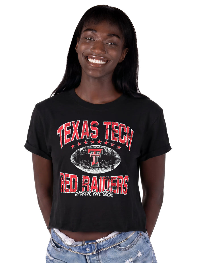 Model wearing the black ZooZatz Texas Tech Prime Time crop tee with distressed red TEXAS TECH and RED RAIDERS lettering around a white football with the Double T and Wreck 'Em Tech script